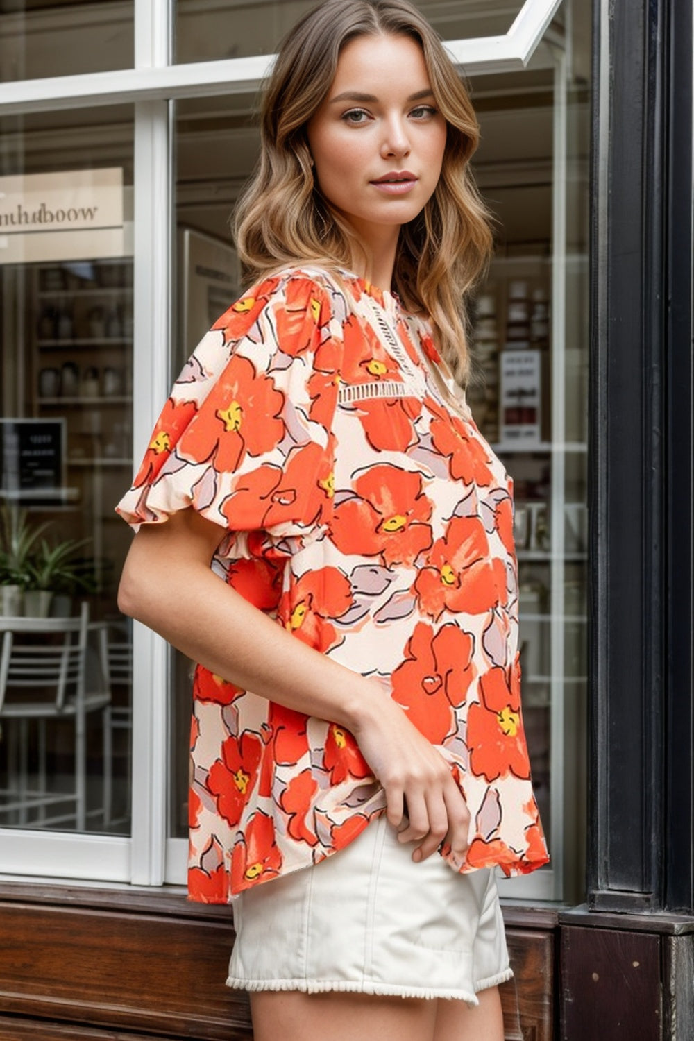Floral print blouse with flutter sleeves and lace trim neckline in caramel.