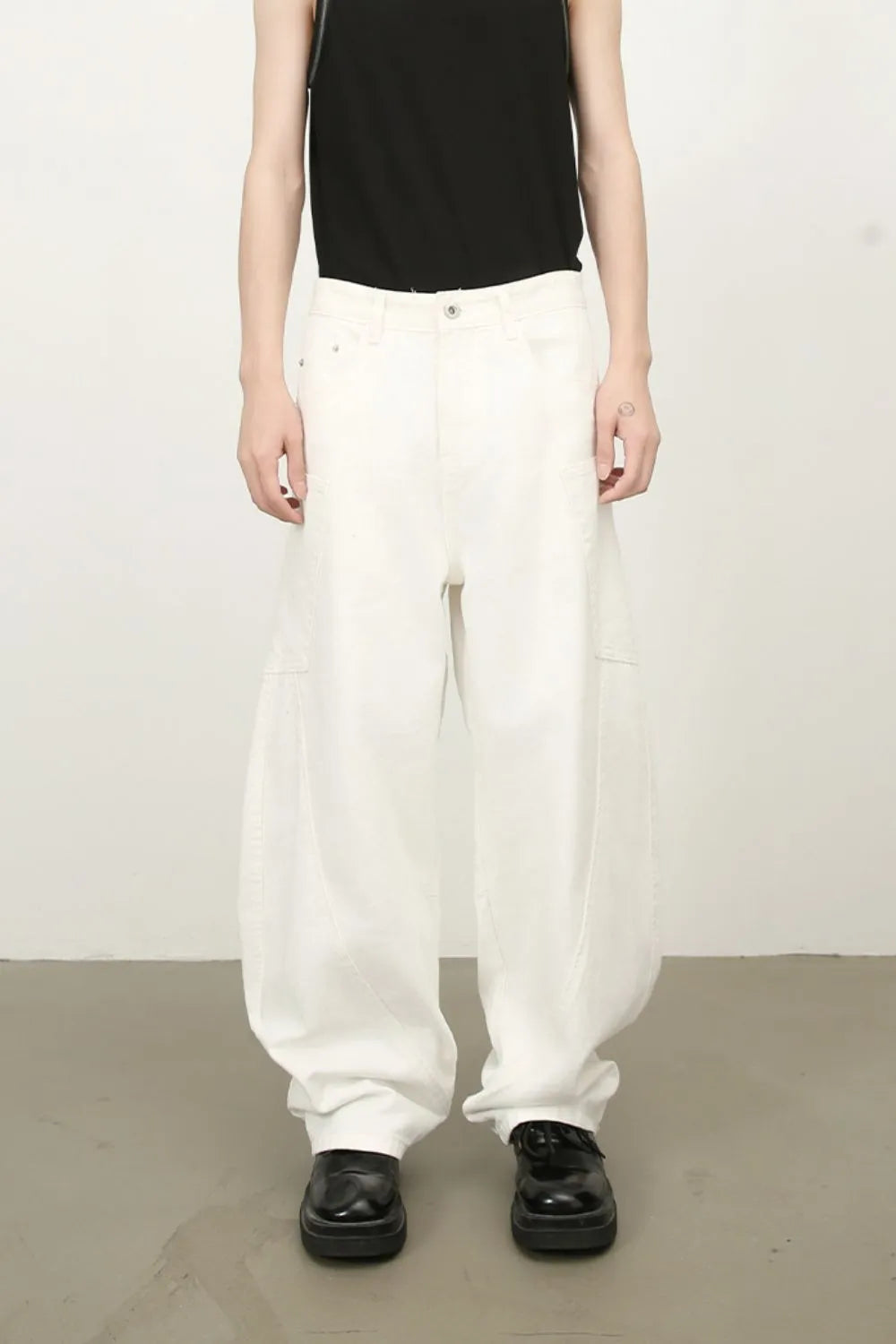 White wide leg trousers with sculpted pocket details and a relaxed fit.