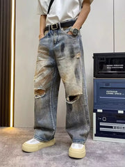 Heavily distressed vintage wide-leg jeans in blue denim with rips and fading.