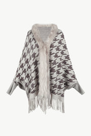 Houndstooth knit poncho with faux fur collar and fringe hem.