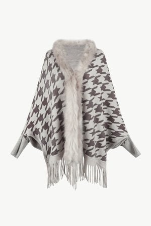 Houndstooth knit poncho with faux fur collar and fringe hem.