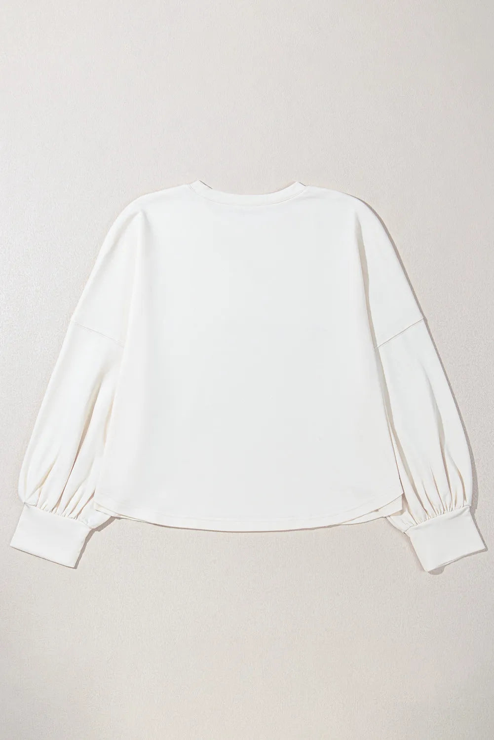 White relaxed fit sweatshirt with gathered balloon sleeves and ribbed cuffs.