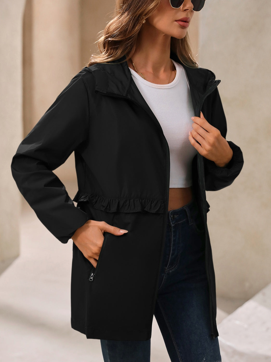 Black hooded windbreaker jacket with ruffled waistline and zip pockets