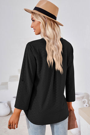Black textured henley shirt with roll-tab sleeves and a curved hem