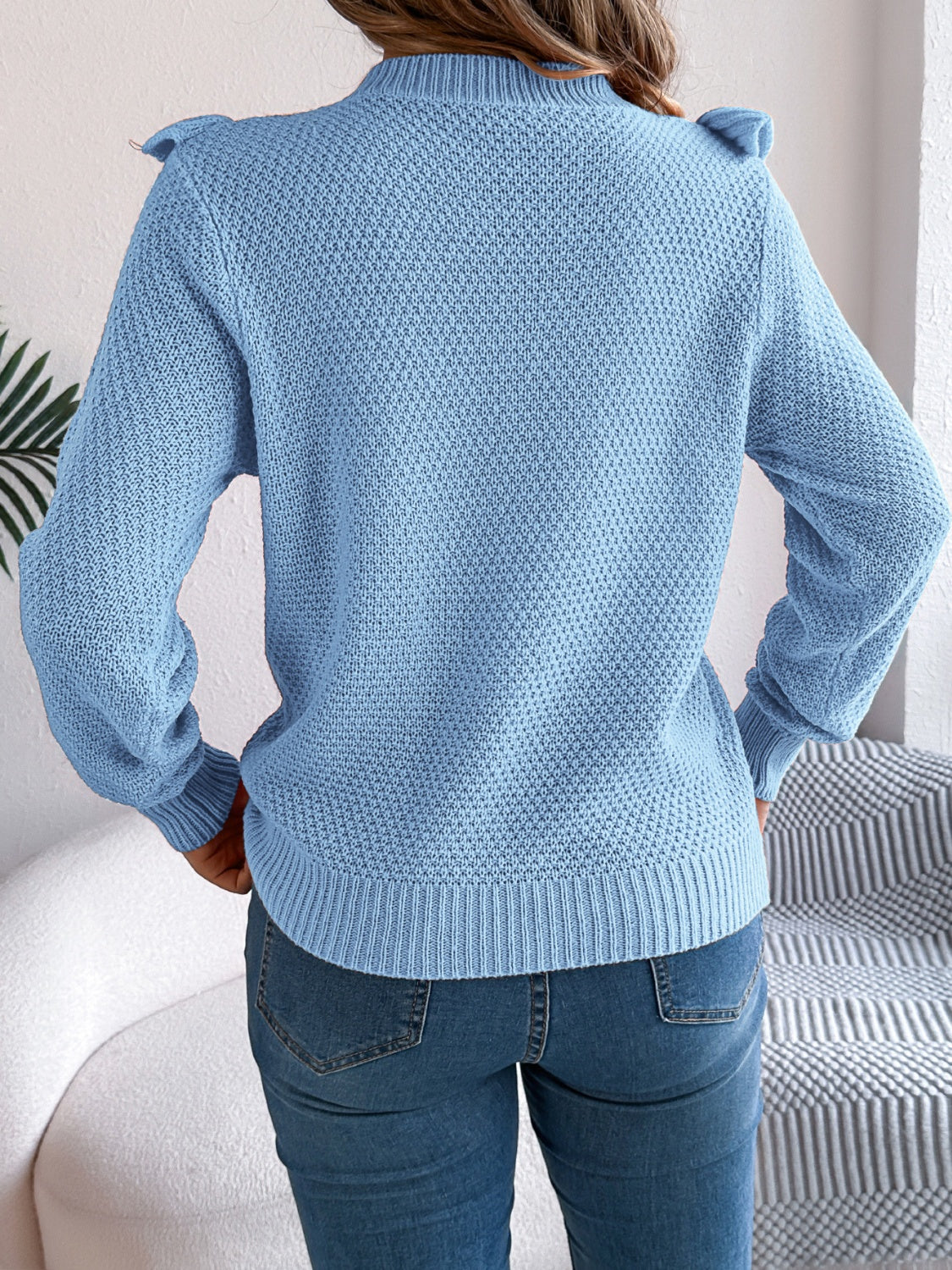 Light blue textured knit sweater with ruffle yoke detail and mock neck.