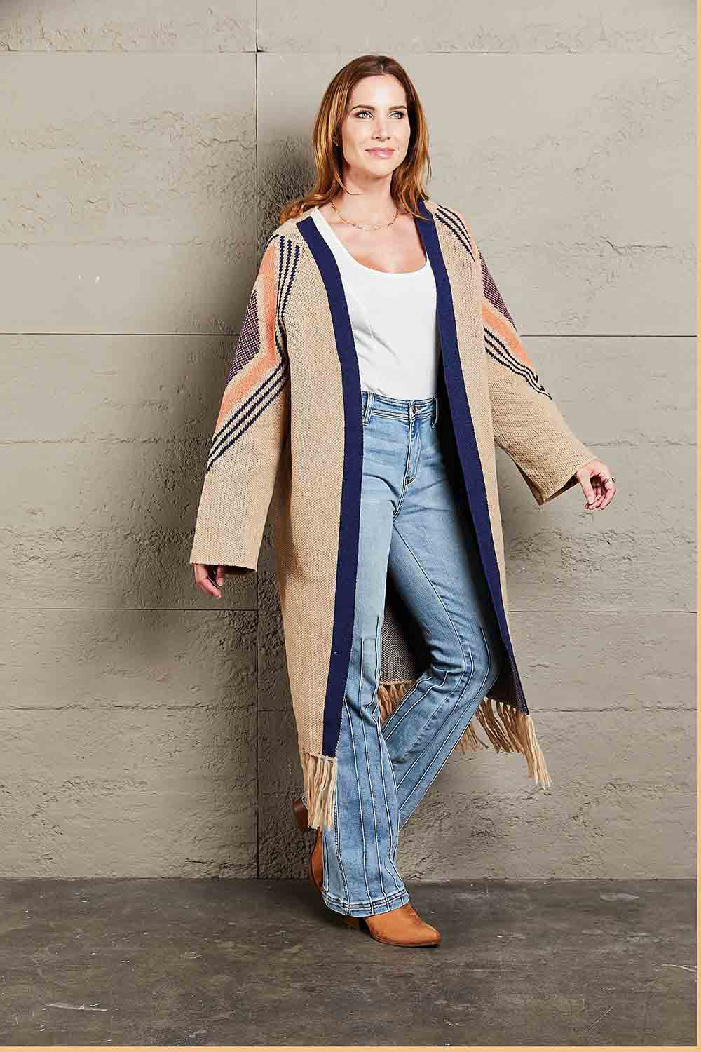 Khaki long cardigan with geometric trim, navy blue trim, and fringed hemline.