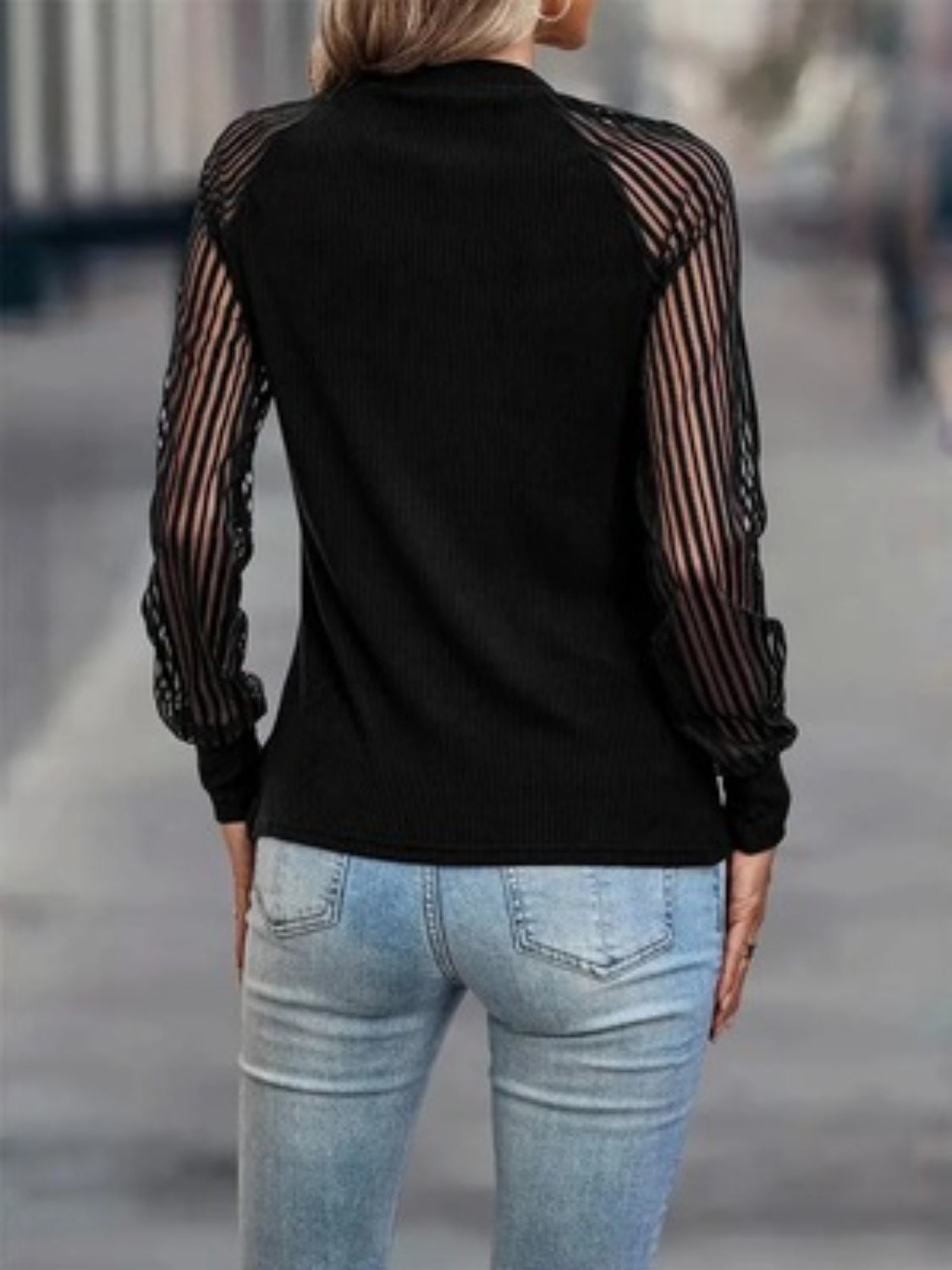 Black ribbed knit sweater with sheer stripe sleeves
