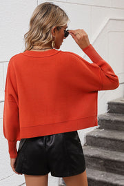 Orange-red cropped dolman sleeve knit sweater with ribbed hem and cuffs.