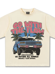 Cream cotton graphic tee with "GO WITH THE FLOW" text, a blue car, and palm trees.