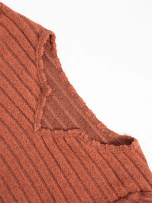 Ribbed knit A-line dress in rust with a V-neck and raw edge detail.