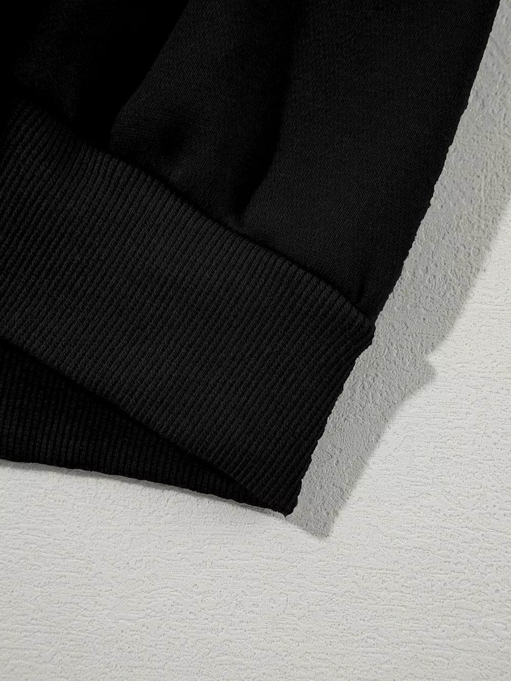 Black cotton joggers with ribbed cuff detail.