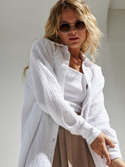 White textured cotton overshirt with relaxed fit and button front, styled with a white tank top.