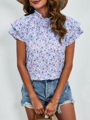 Light blue floral blouse with ruffled neckline and flutter sleeves