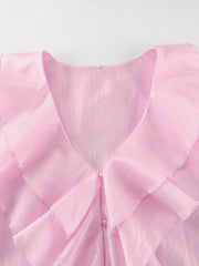 Pink ruffle trim blouse with pearl buttons and V-neckline.