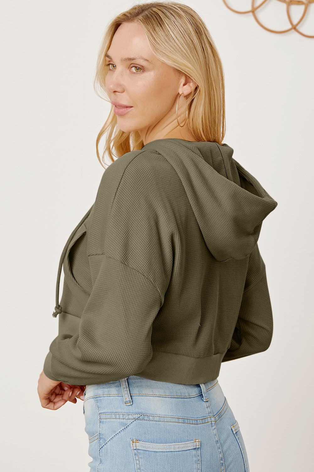 Army green waffle knit cropped zip hoodie with drawstring hood and front pocket detail.