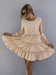 Apricot ruffled mini dress with long sleeves and tiered skirt.