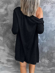 Black cotton cardigan with long sleeves and a relaxed fit, styled off the shoulder.