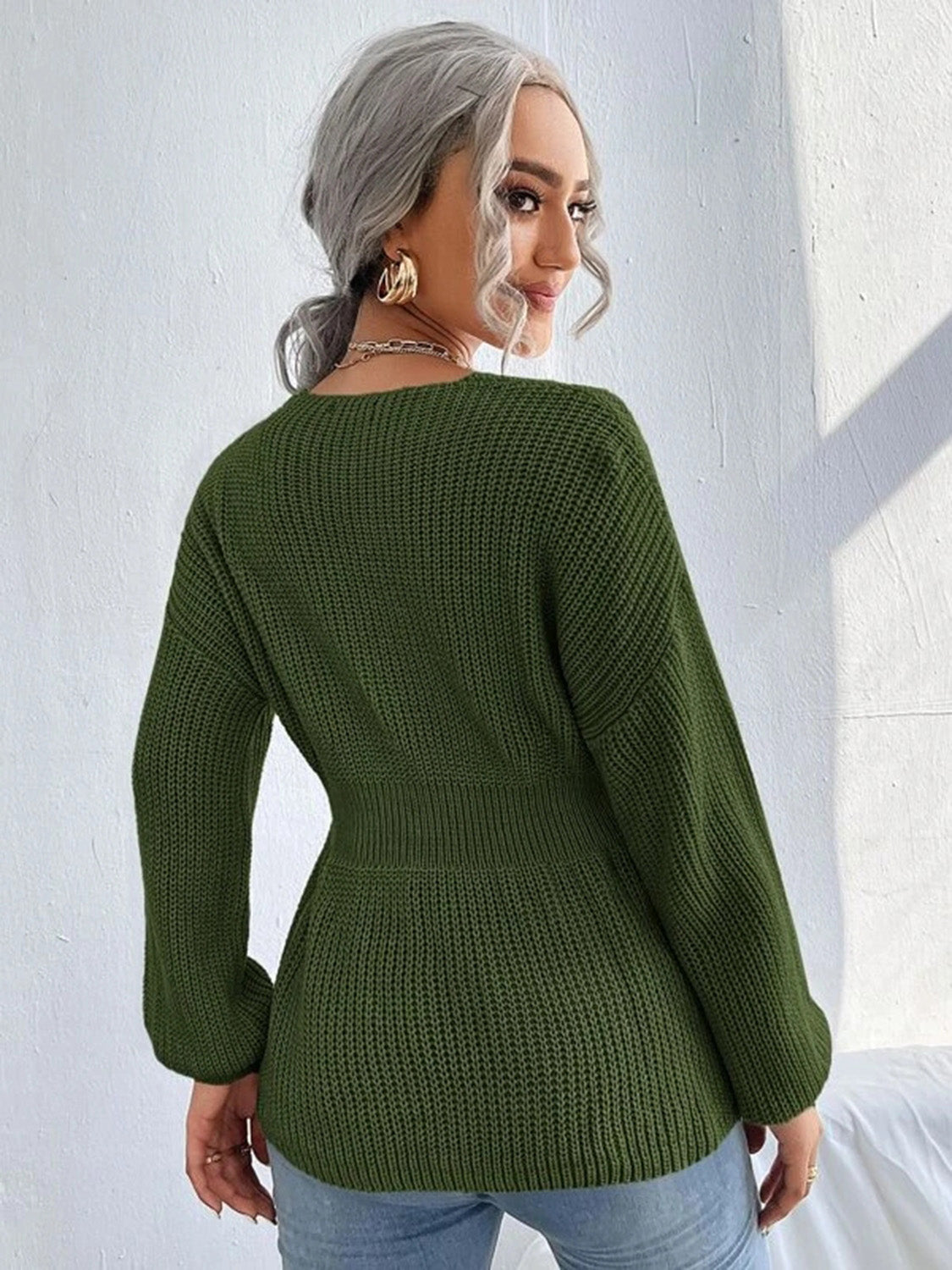 Green peplum knit sweater with scallop neckline and long sleeves.