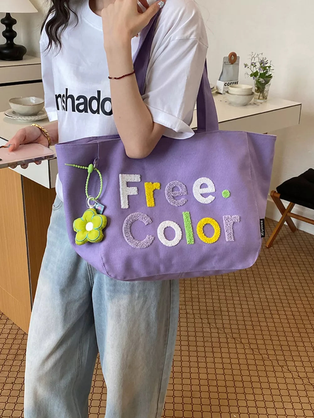 Lavender canvas shoulder bag with embroidered Free Color text and flower charm