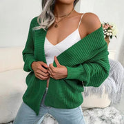 Green chunky knit dolman sleeve cardigan with ribbed texture and open front.