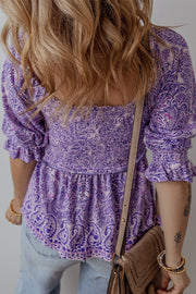 Paisley print smocked bodice blouse in lavender with square neckline and ruffled sleeves.