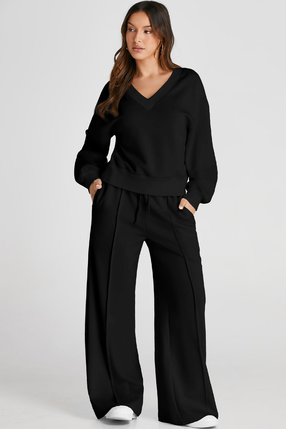 Black V-neck loungewear set with wide-leg pants featuring seam detail.