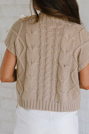 Mocha cable knit mock neck sweater with short sleeves and bow detail on shoulder.