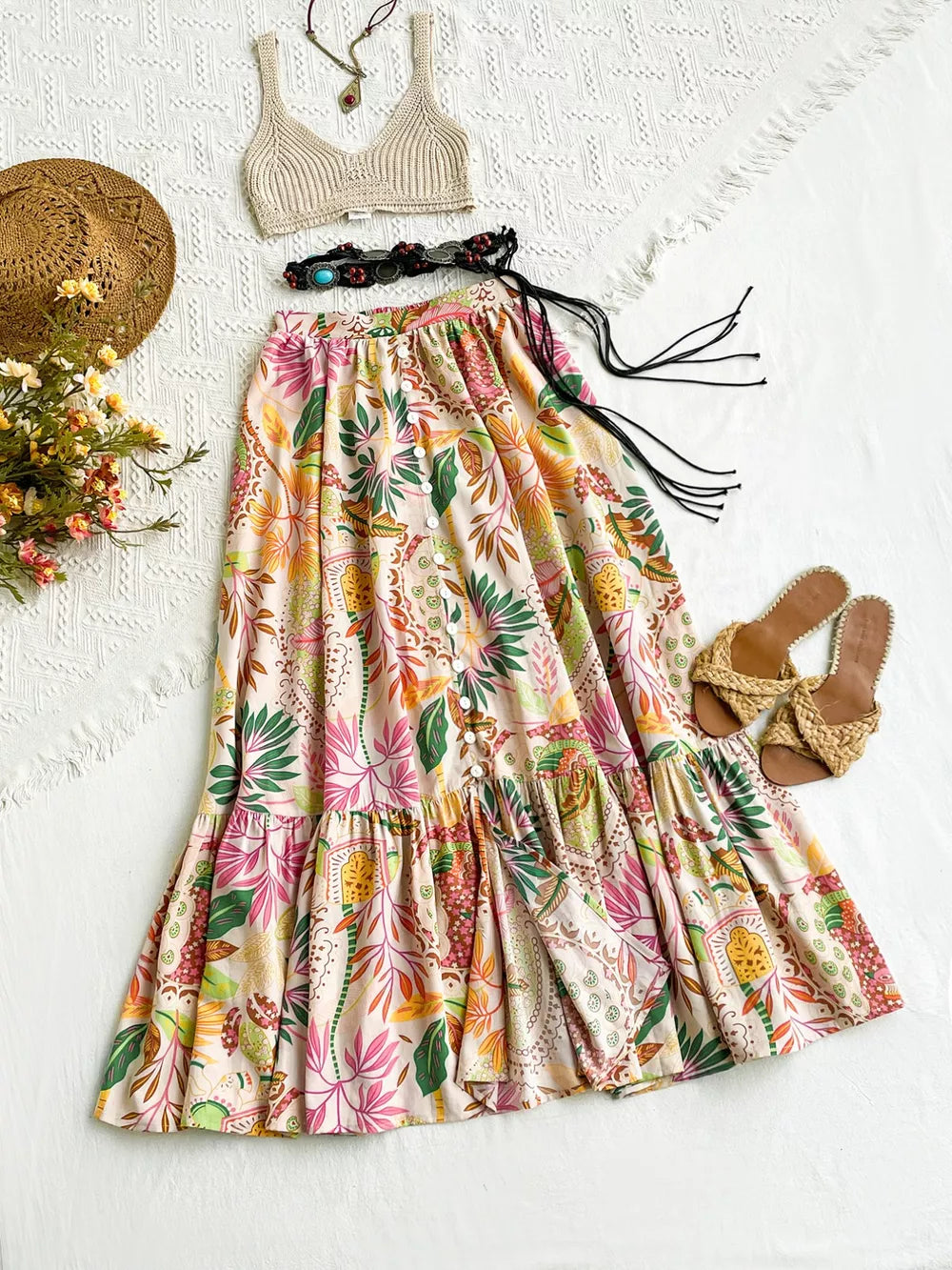 Tropical ruched maxi skirt with ruffles and decorative buttons, featuring a vibrant floral print.