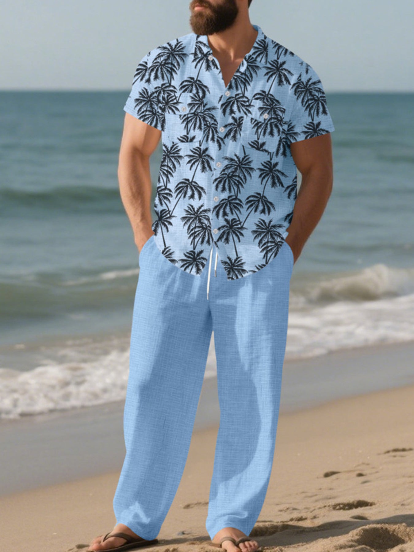 Men's pastel blue relaxed fit pants with drawstring waist, paired with a tropical palm print short sleeve button-down shirt.