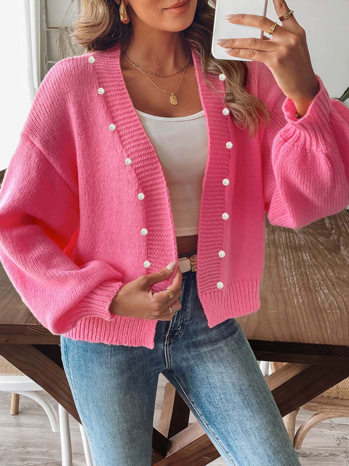 Fuchsia pink bubble sleeve cardigan with pearl buttons and V-neck.