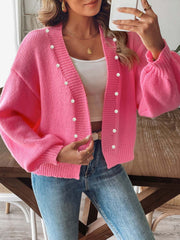 Fuchsia pink bubble sleeve cardigan with pearl buttons and V-neck.