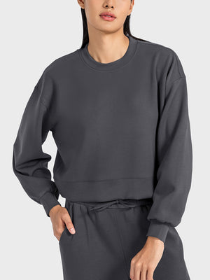Dark blue cropped crewneck sweatshirt with gathered sleeves and crew neckline.