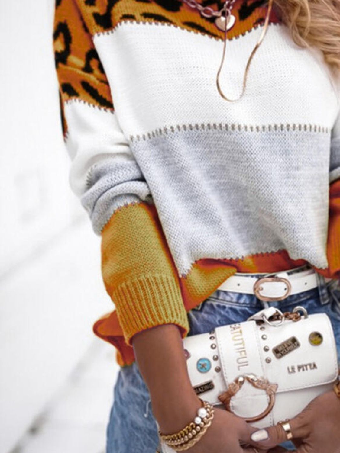 Leopard panel knit sweater with colorblock white, gray, and gold sleeves.