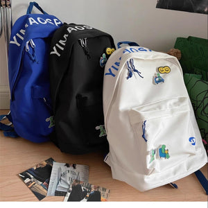 Nylon medium backpack in off-white with utility pocket and cute cartoon patches.