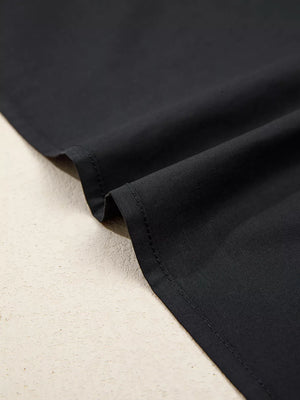 Black maternity overshirt detail showing fabric texture and stitching.