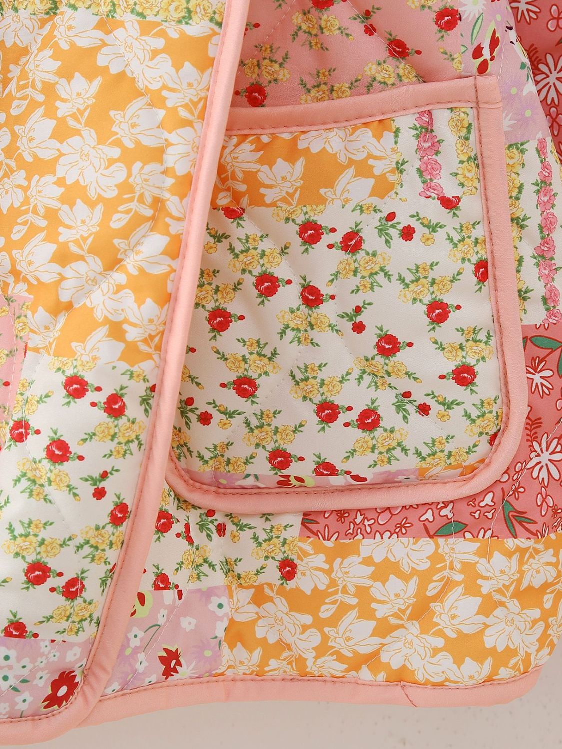 Floral quilted patchwork jacket with pink trim and pocket detail.