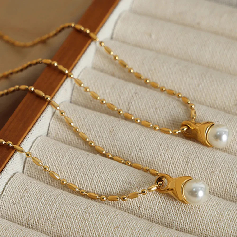 Gold pearl drop necklace with a delicate beaded chain.