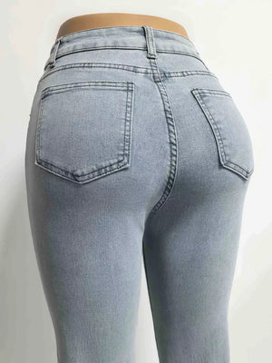 Light blue denim maternity jeans with pockets, shown from the back.