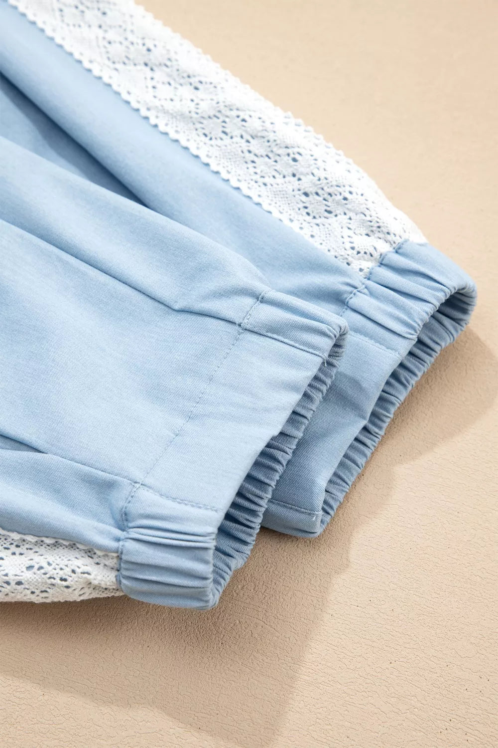 Light blue maternity pants with white lace trim and elastic cuffs.