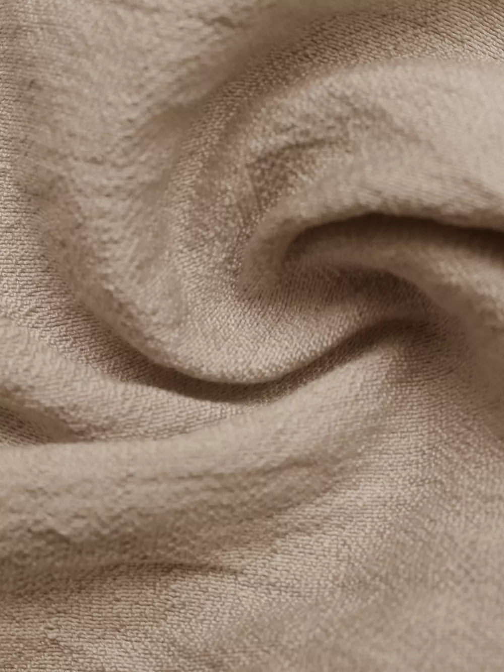 Textured beige maxi dress fabric detail, showing a soft, crinkled weave.