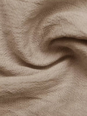 Textured beige maxi dress fabric detail, showing a soft, crinkled weave.
