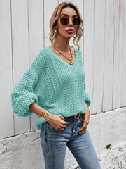 Teal open-knit sweater with balloon sleeves and V-neck, styled with jeans.