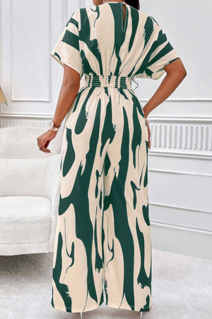 Dark green and cream abstract brushstroke wide-leg jumpsuit with short sleeves and smocked waist.