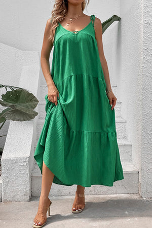 Green tiered maxi dress with delicate tie straps and textured fabric.