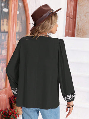 Black embroidered yoke blouse with gathered bodice and embroidered cuffs.