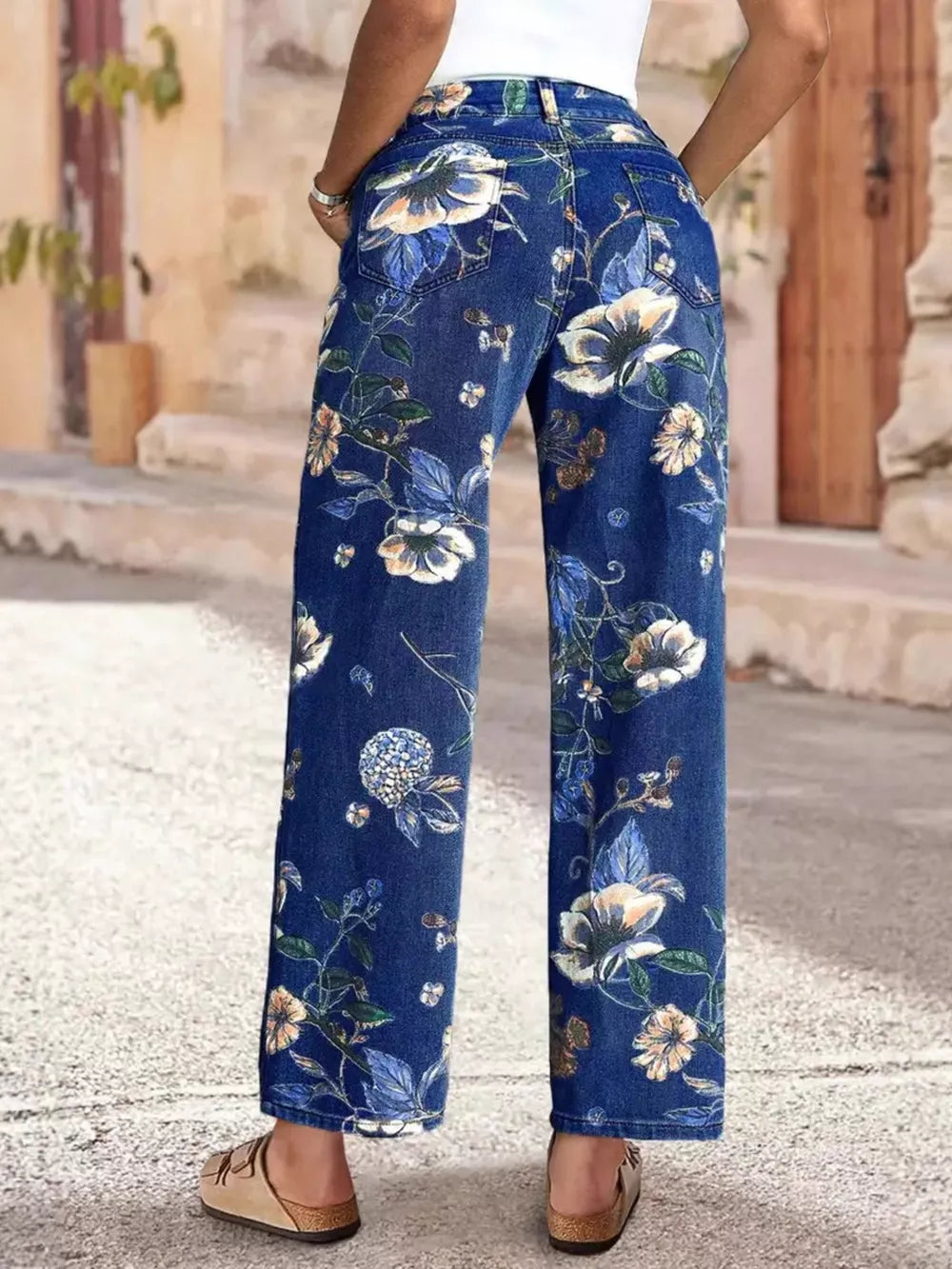 Light blue denim wide-leg jeans with a floral print and embellished details.