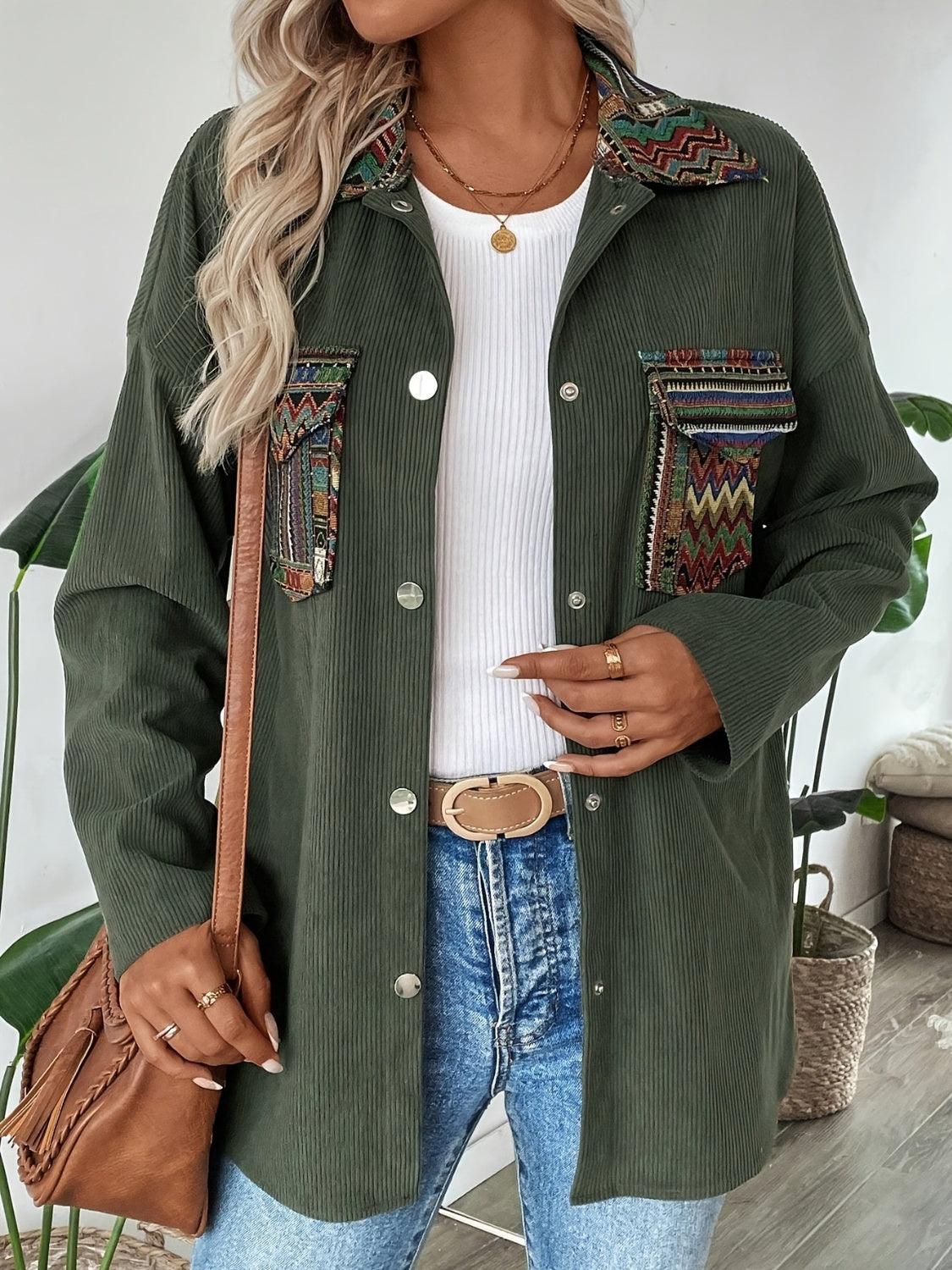 Army green corduroy overshirt with embroidered statement pockets and collar detail.