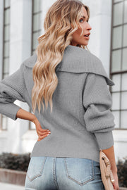 Gray ribbed knit cardigan with shawl collar and cuffed sleeves, worn with jeans.