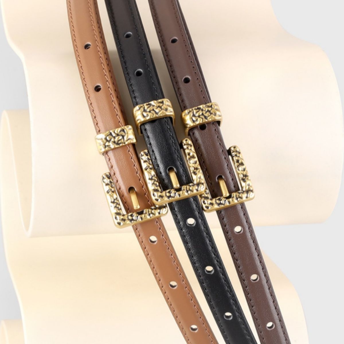 Ornate buckle cowhide leather belts in coffee brown, black, and brown with gold buckles.