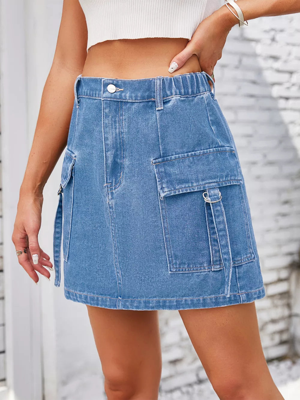Denim cargo skirt in Dusty Blue with utility pockets and a comfortable elastic waistband.